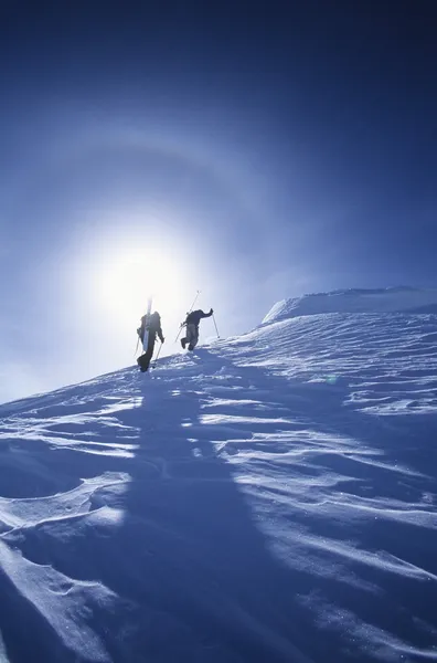 Skiers hiking to mountain summit