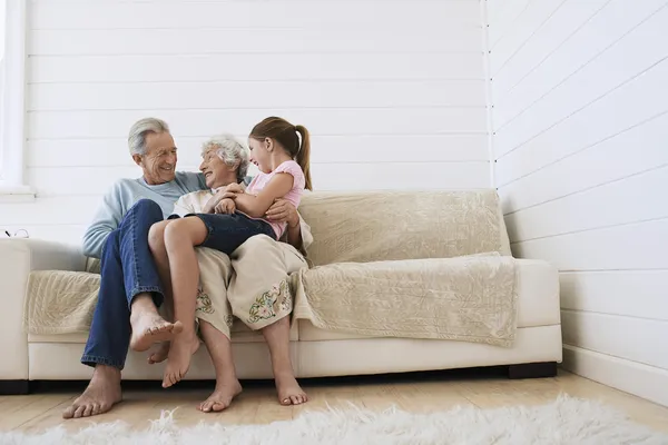 Grandparents With Granddaughter on Sofa