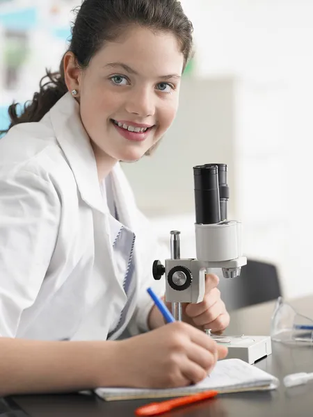 Teenage girl using microscope