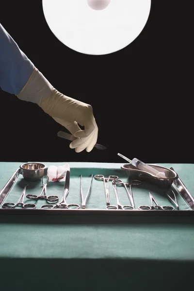 Surgeons hand reaching for medical equipment