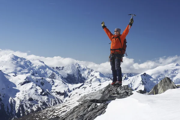 Mountain climber with arms raised