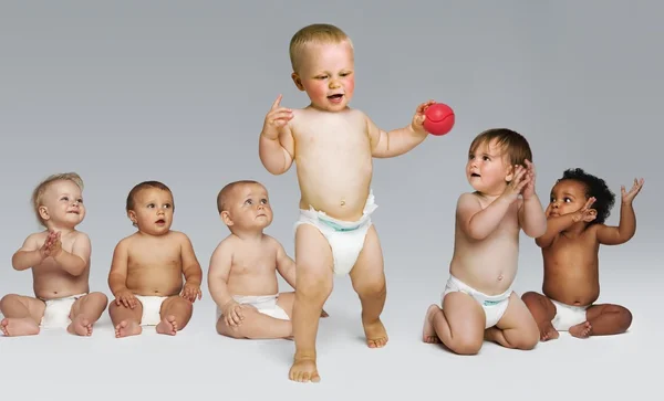 Babies looking at a toddler take first steps