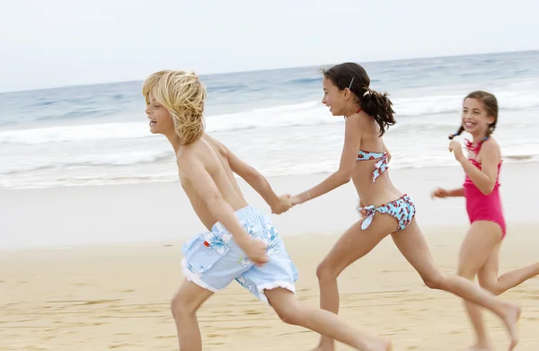 Children  running along sandy beach