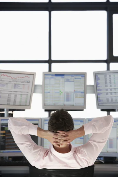 Businessman watching computer screens