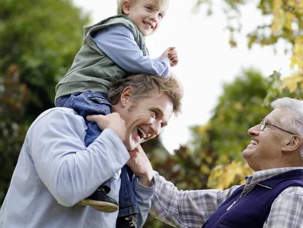 Boy riding on father's shoulders