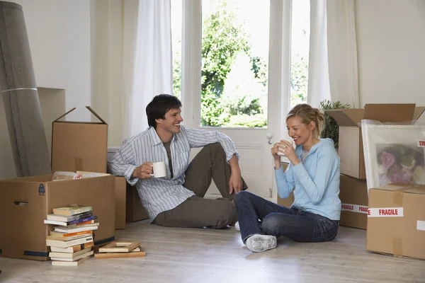 Couple taking a break among moving boxes