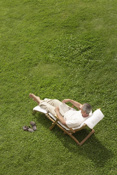 Man in deck chair reading