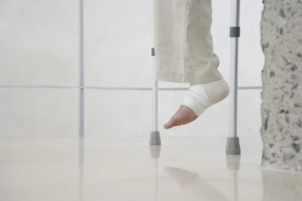 Human foot of person on crutches