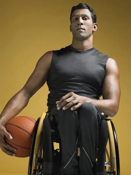 Paraplegic athlete holding basketball