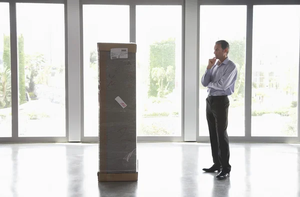 Businessman Looking at Large Package