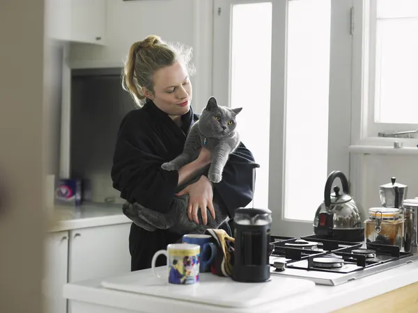 Woman with cat in kitchen