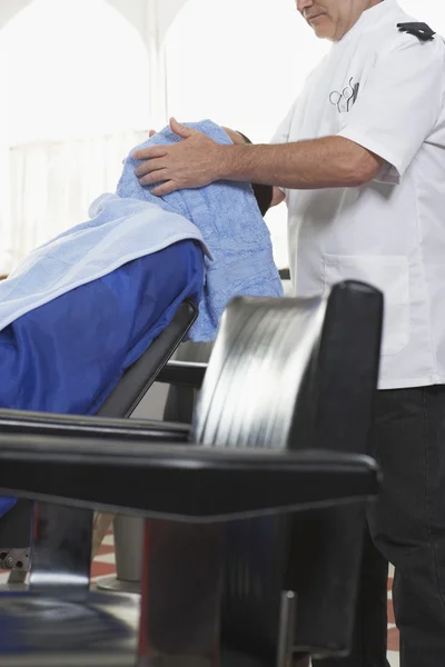 Barber drying mans hair