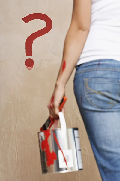Woman holding painting can and question mark