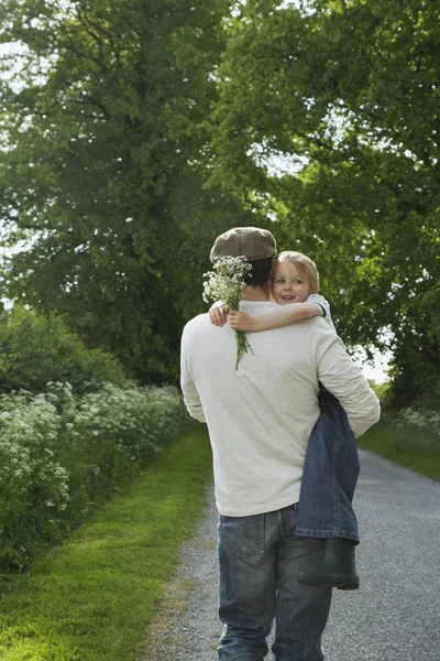 Father Carrying Daughter with Wildflowers