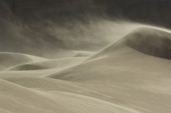 Sand blowing over sand dune