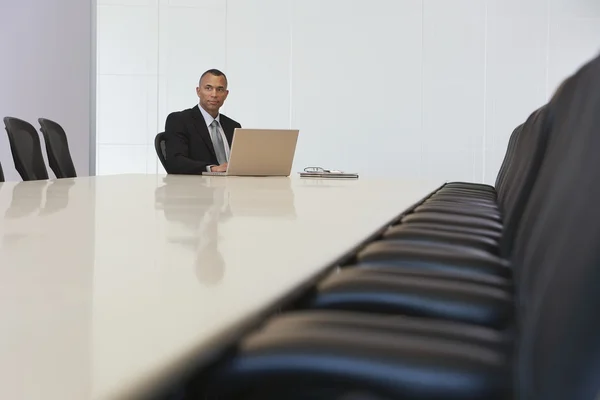 Businessman with laptop in board room