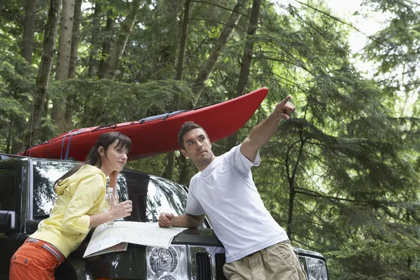 Couple with map on car bonnet