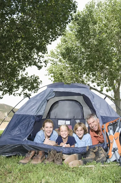 Family smiling from a tent