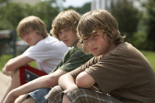 Brothers sitting on street curb