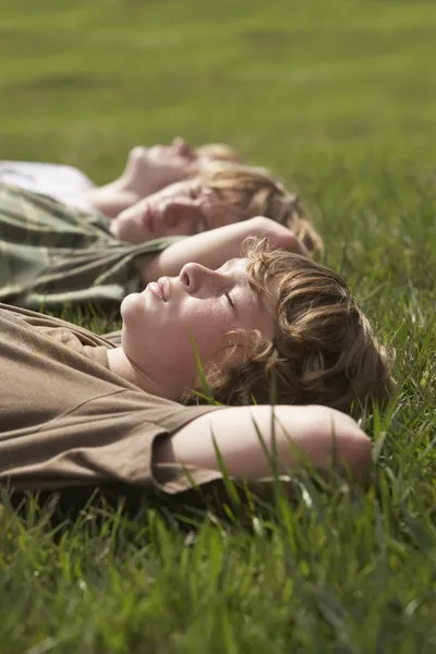 Brothers lying on grass