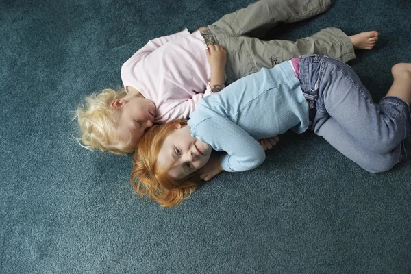 Sisters lying on carpet