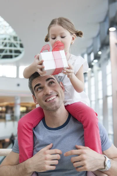 Daughter sits on fathers shoulders