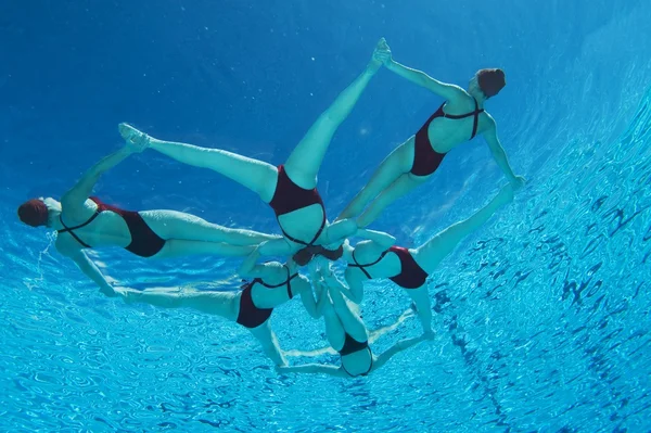Synchronised swimmers form a star underwater view