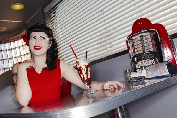Retro woman in red dress in American diner