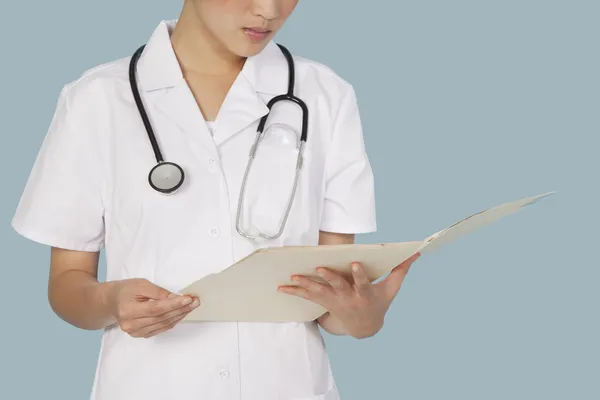 Female doctor reading medical report