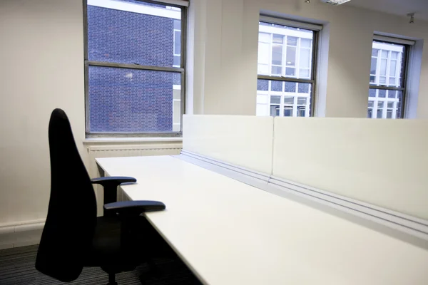 Office chair and empty desk by window