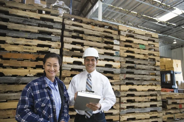 Woman and man standing in distribution warehouse
