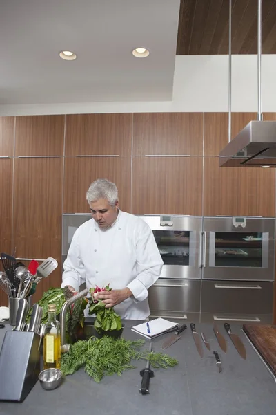 Mid- adult chef washing leaf vegetables