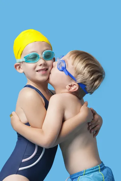 Young siblings in swimwear embracing