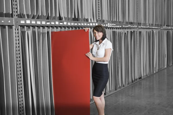 Businesswoman holding thin red veneer sheet