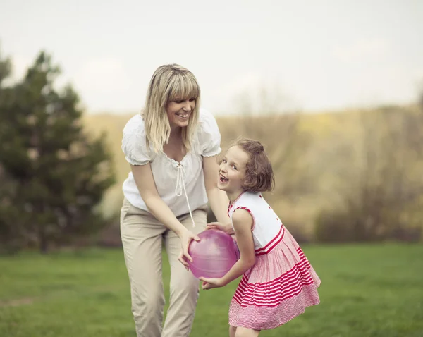 Mother and daughter playing with ball