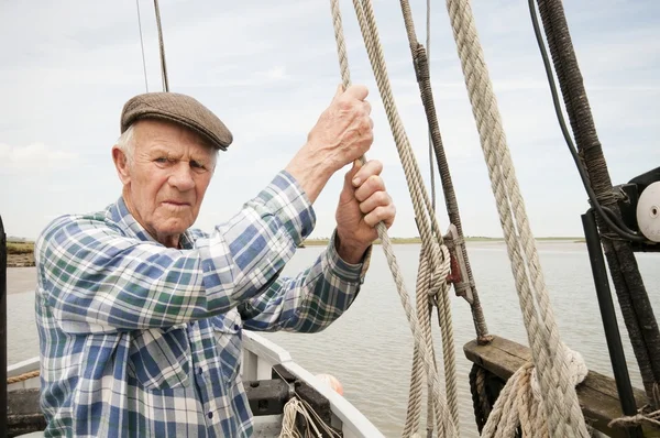 Elderly fisherman pulling rope