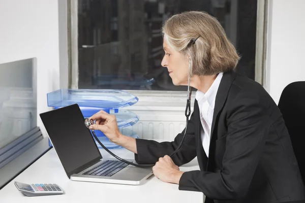 Senior businesswoman examining laptop