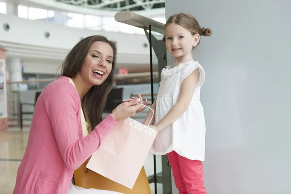 Mother giving daughter shopping bag