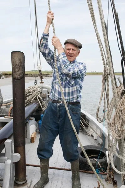 Elderly fisherman pulling rope