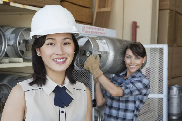 Woman smiling with female industrial worker