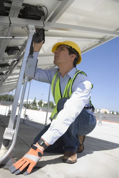 Maintenance worker adjusting solar panel