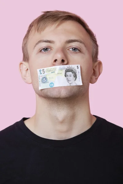 Man with paper money stuck over mouth