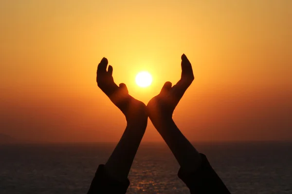 Man hands holding the sun at sunrise