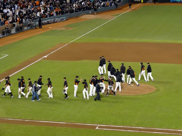 Giants high five each otheron field after winning game