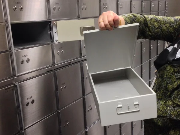 Women showing a medium size safe deposit box