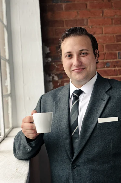 Suit man drinks coffee and thinks