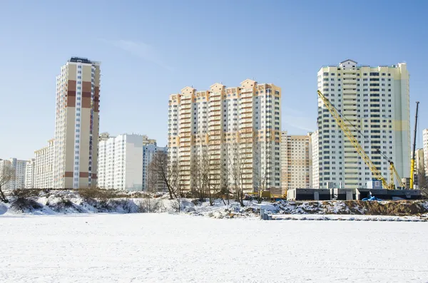 The construction of new residential buildings in Moscow on a background of a winter landscape.