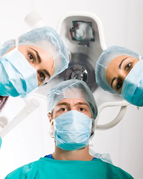 Group of surgeons looking at patient in operation room