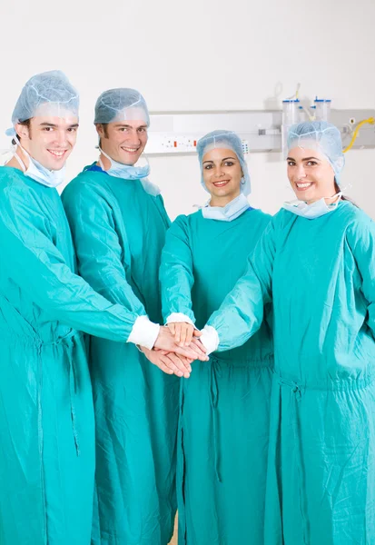 Group of medical workers put hands together to form teamwork