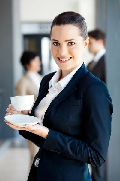 Beautiful young businesswoman drinking coffee